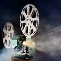 Old retro movie projector with smoke and light beam